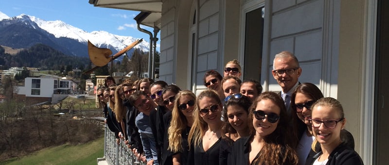 Die Studiengruppe BKO-N13 der HWZ, Dorothea Tiefenauer, CEO Christian Zünd vom Kaufmännischen Verband und HWZ-Dozent und Seminarleiter Stefan Vogler freuen sich in Scuol über den erfolgreichen Abschluss der Projektwoche, die präsentierten Lösungen und die warme Frühlingssonne.